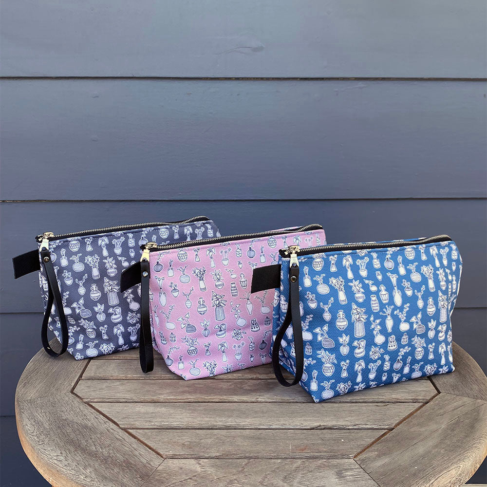 Large Carry All Make Up Bag with denim lining. Plant doodle pattern. Shown on table.