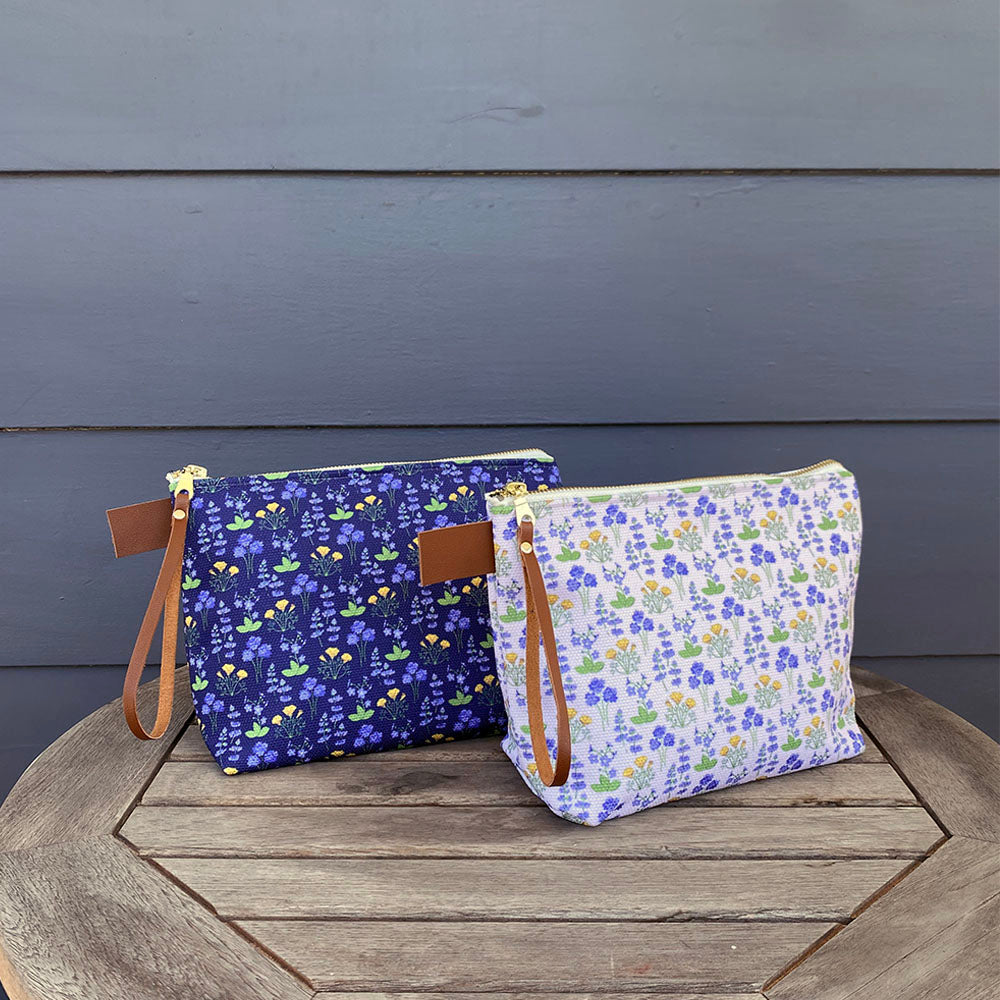Large Carry All Make Up Bag with denim lining. Wildflower floral pattern. Shown on table.