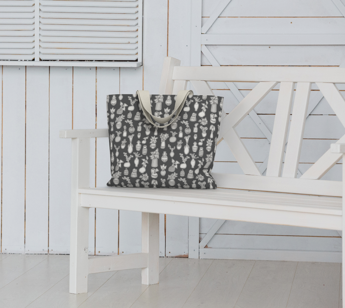 Oversized Fully Lined Cotton Tote Bag with sturdy 1 ½ inch strap. Whimsical gray pattern featuring doodles of house plants. Shown on white bench.