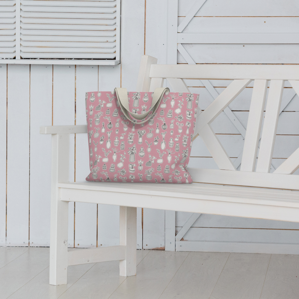 Oversized Fully Lined Cotton Tote Bag with sturdy 1 ½ inch strap. Whimsical pink pattern featuring doodles of house plants. Shown on white bench.