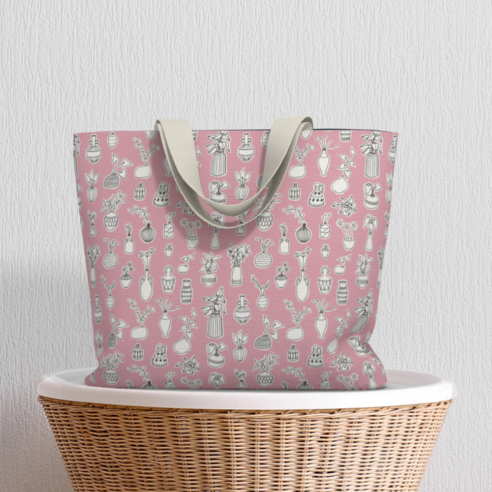 Oversized Fully Lined Cotton Tote Bag with sturdy 1 ½ inch strap. Whimsical pink pattern featuring doodles of house plants. Shown on wicker basket.