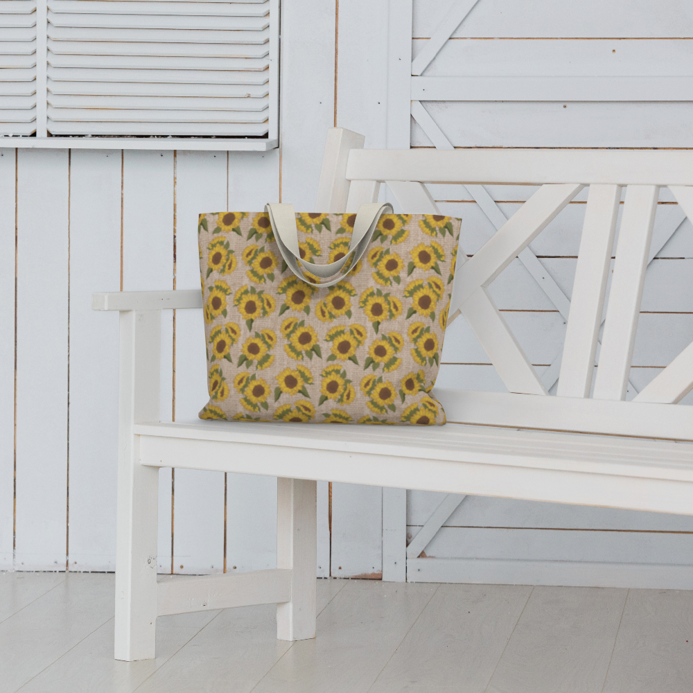 Oversized Fully Lined Cotton Tote Bag with sturdy 1 ½ inch strap. Sunflower floral pattern. Shown on white bench.