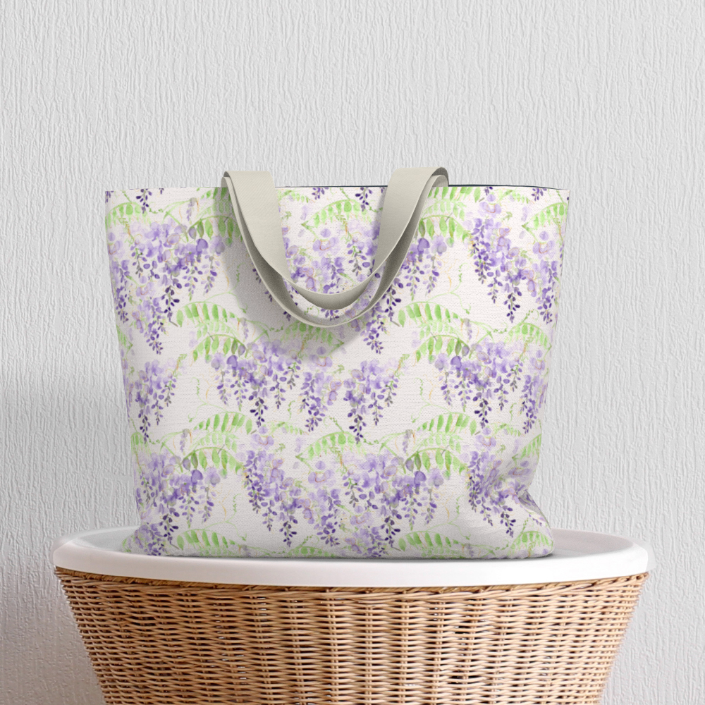 Oversized Fully Lined Cotton Tote Bag with sturdy 1 ½ inch strap. Purple wisteria floral pattern. Shown on wicker basket.