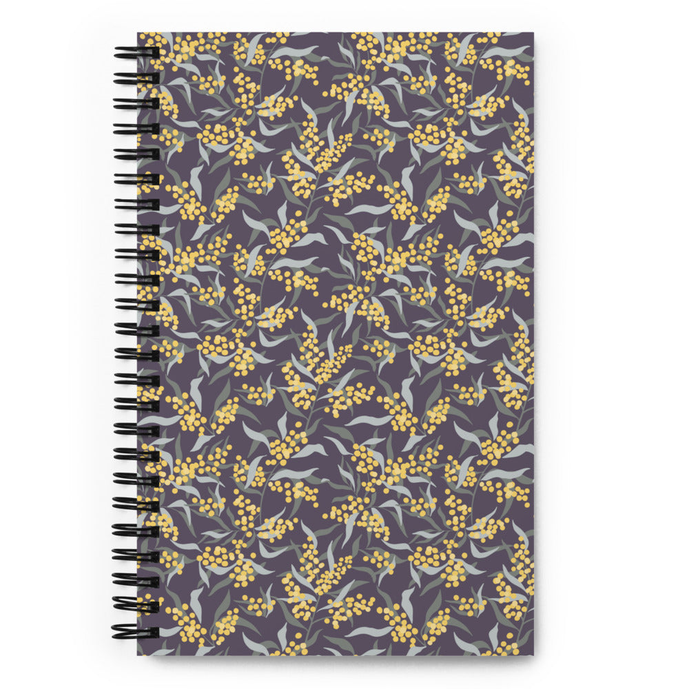 Bullet journal spiral notebook with mimosa branch pattern, dark background. Front cover.
