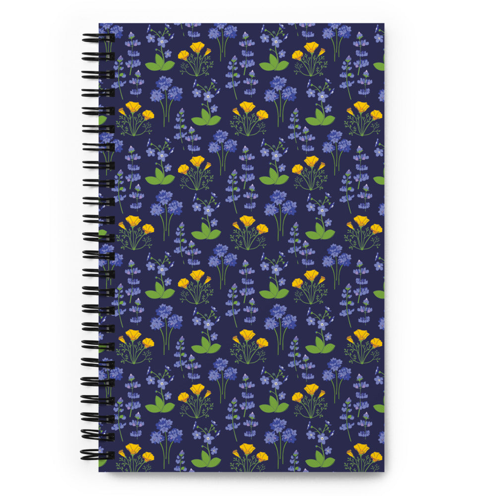 Bullet journal spiral notebook with wildflower pattern on a dark background. Front cover.