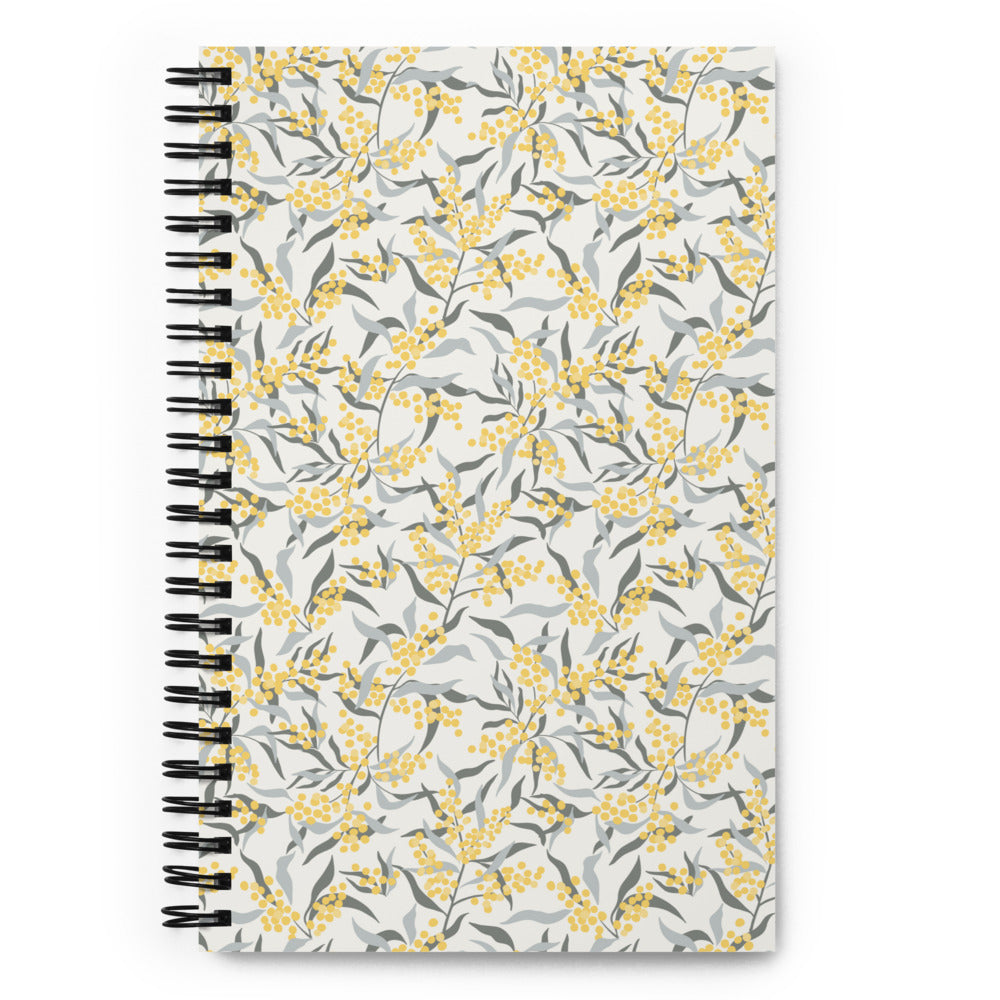 Bullet journal spiral notebook with mimosa branch pattern, light background. Front cover. 